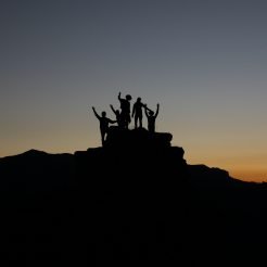 team reaching top of a hill